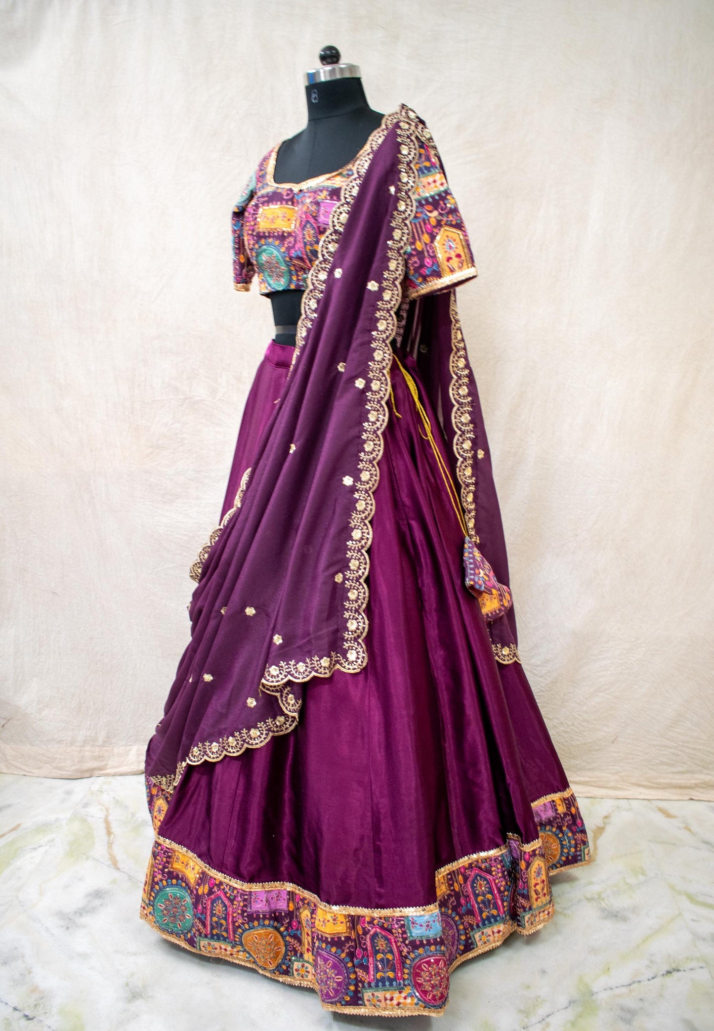 detailed hand embroidery on purple lehenga with gold threadwork and sequins