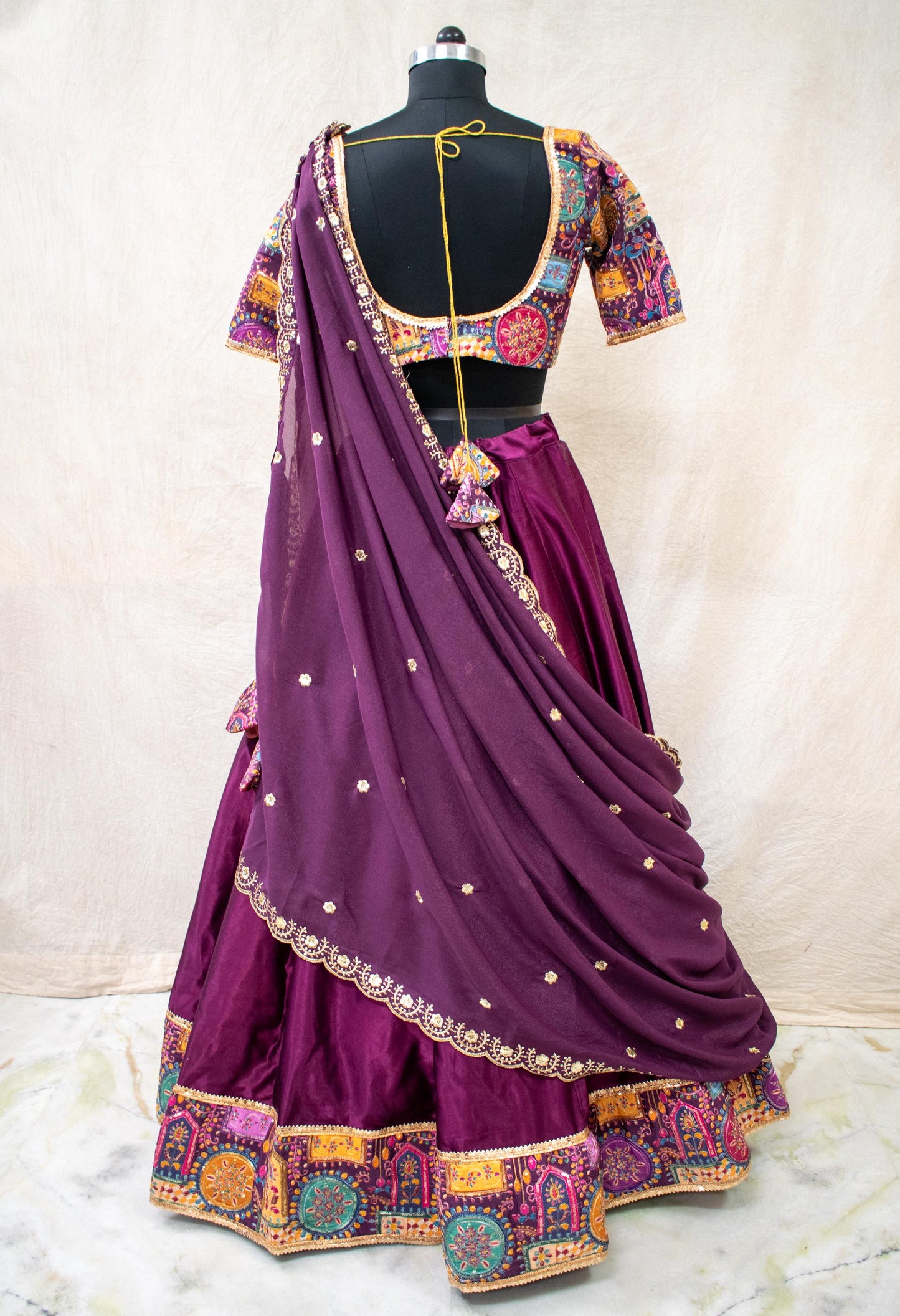 back view of purple silk lehenga choli with flared skirt and dupatta
