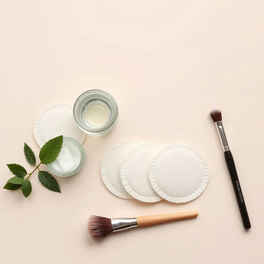 Biodegradable makeup pads and a brush arranged neatly on a neutral background for gentle makeup removal