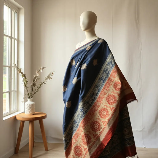 Kalamkari saree draped with detailed block-printed motifs in earthy tones on a neutral backdrop