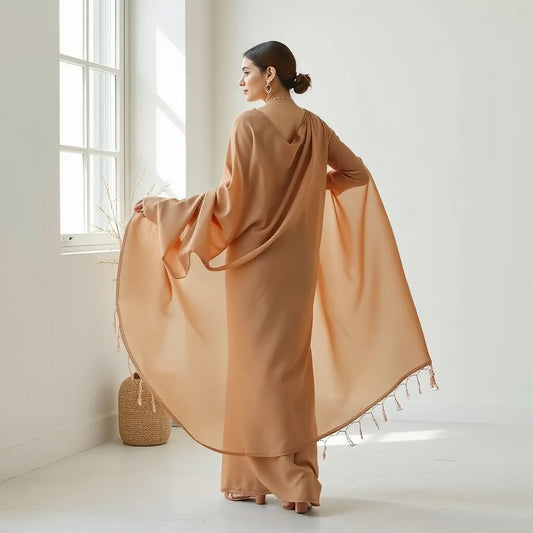 Woman draped in a flowing georgette saree with neatly pinned pleats and graceful folds in soft natural light.