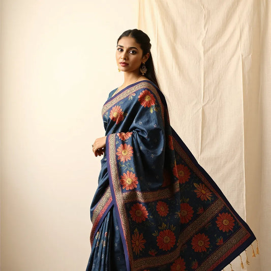 Model draped in a Kalamkari saree with bold hand-painted motifs in indigo, red, and cream under soft natural light