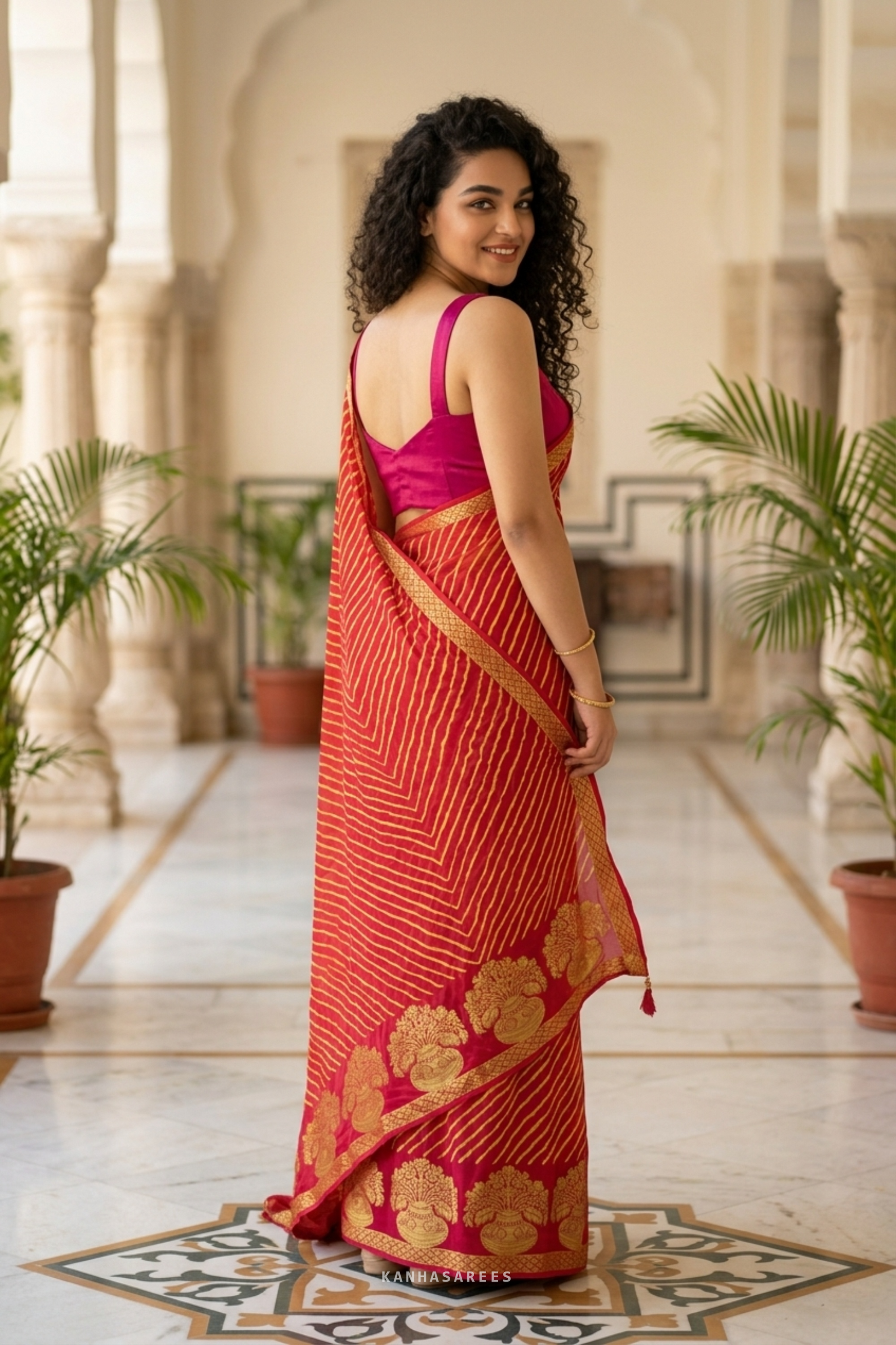 Detailed shot of the red georgette leheriya saree's gold zari border and traditional pattern.